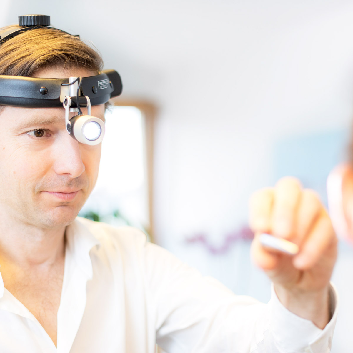 HNO-Arzt untersucht die Nase mit Stirnlampe – fachärztliche Diagnostik bei Nasen- und Nebenhöhlenbeschwerden.