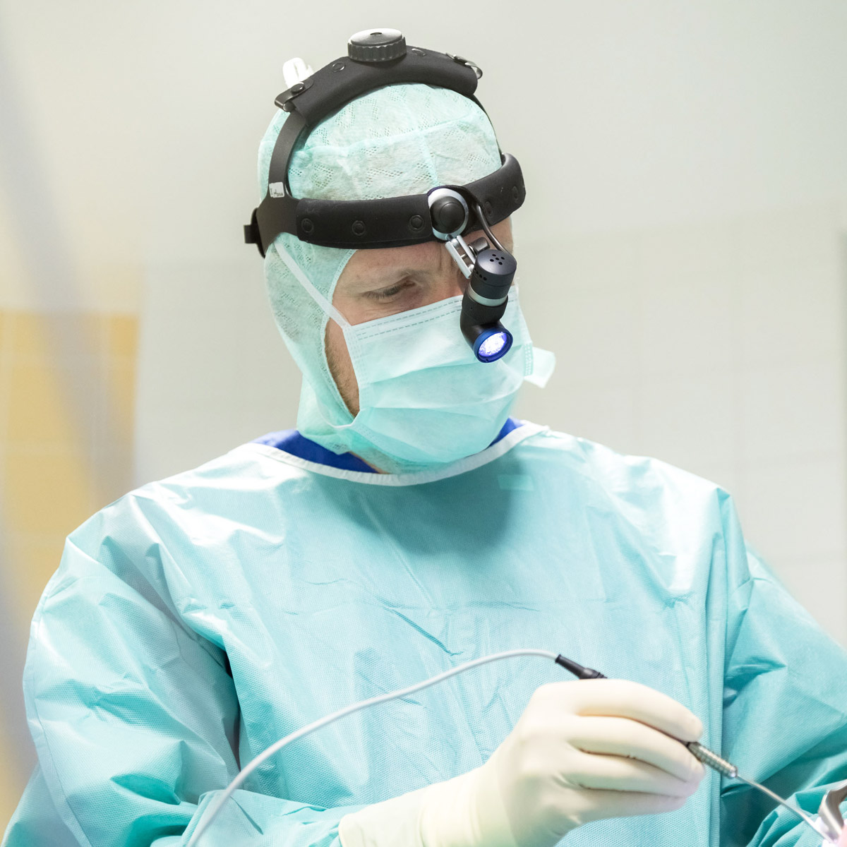 HNO-Arzt untersucht das Ohr einer Patientin mit einem medizinischen Untersuchungsinstrument in der Praxis.